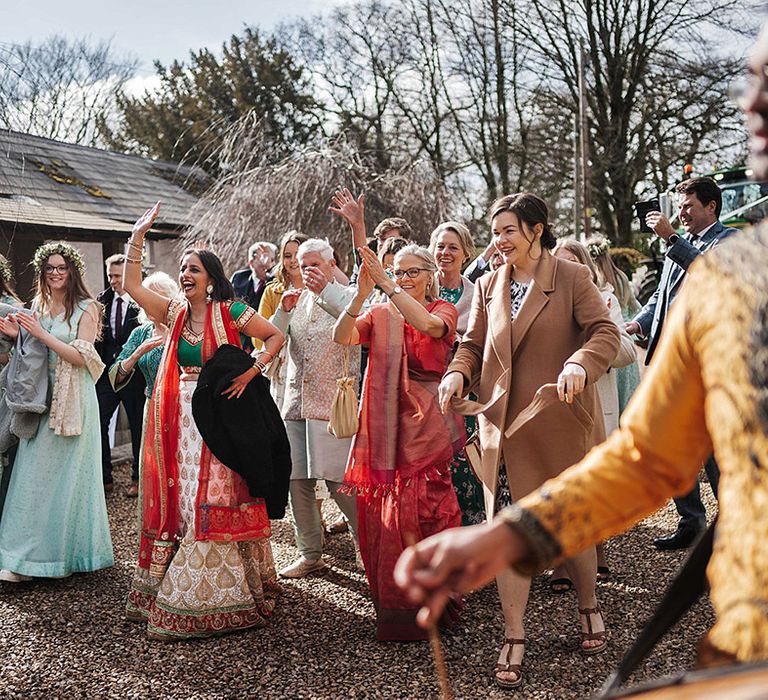 Wedding guests stand and cheer for the bride and groom as they are announced as married