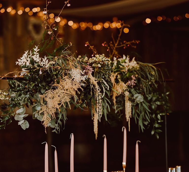 Montague Farm Hankham wedding reception table with floral installation, taper candles and coloured tableware