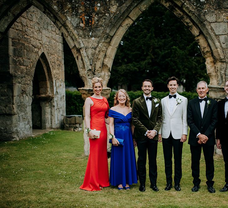 Grooms stand with wedding party in evening wear at Birdsall House 