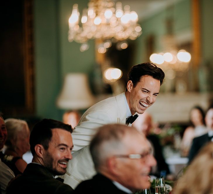 Groom laughs during wedding speeches at reception in Birdsall House 