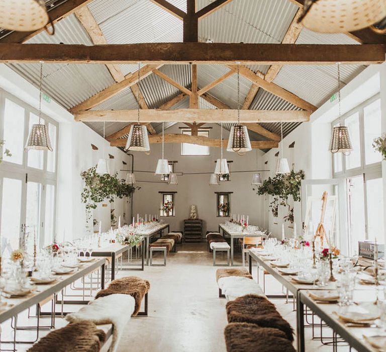 The Barn at Drovers wedding venue with foliage decor and fur covered seats 