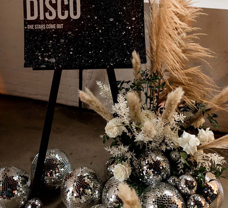 Black and white wedding sign decorated with disco balls for the wedding reception 