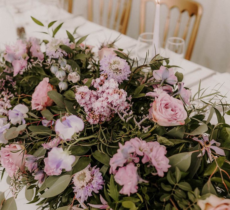 Purple wedding flowers decorate the wedding table 