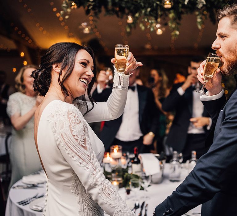 Bride and groom cheers together and sip some champagne to celebrate their wedding 