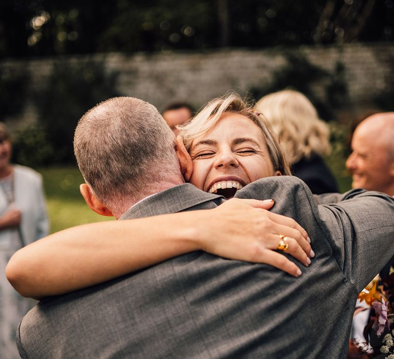 Bride hugs wedding guest after wedding ceremony 