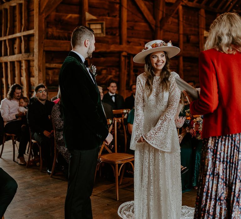 The bride smiles brightly as she stands at the altar with the groom for their wedding ceremony 