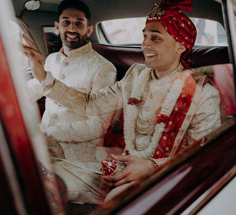 Groom wears red, white and gold sherwani as he makes his way to wedding ceremony 