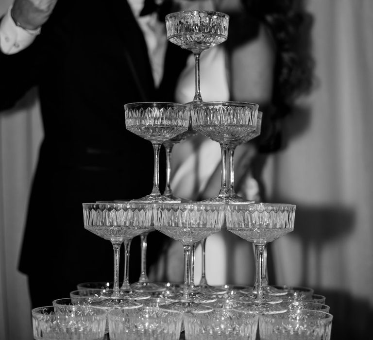 Bride and groom kissing whilst pouring champagne into wedding champagne tower 