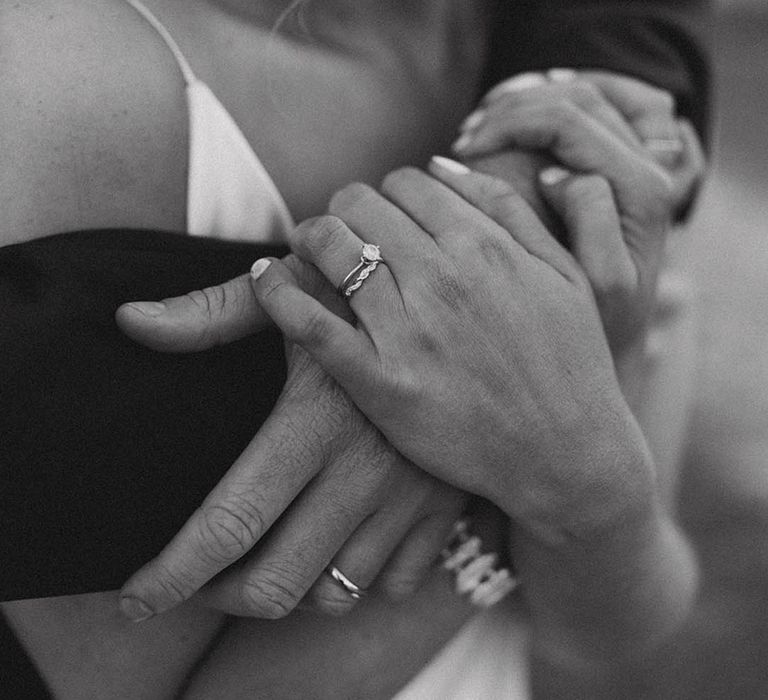 Bride with round brilliant diamond engagement ring with twisted silver wedding band and the groom wears a plain silver wedding band 