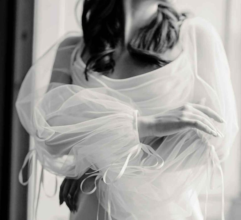 Close up shot of the long sheer puff sleeves on cowl neck satin wedding dress 