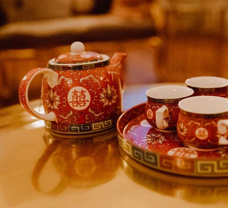 Red Chinese teapot and tea cups on red Chinese tray at Chinese Tea Ceremony wedding 