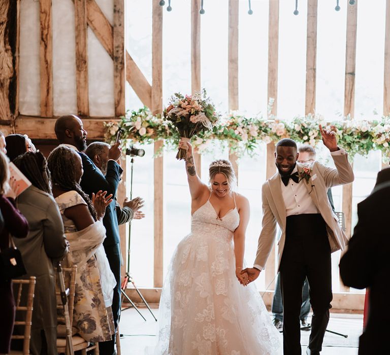 The bride and groom walk back down the aisle as a married couple at their heartfelt Colville Hall wedding 