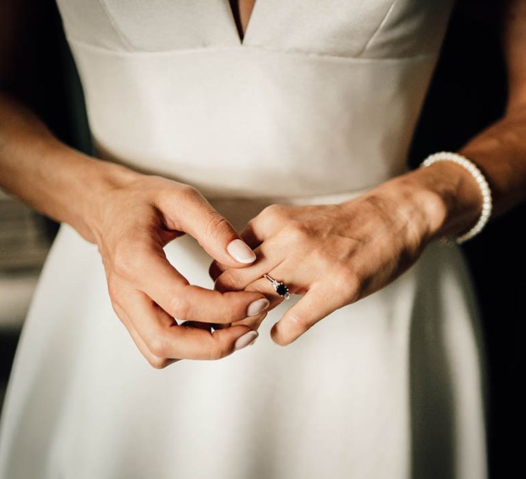 Bride with neutral pink wedding nails with micro french tip wearing her engagement ring 