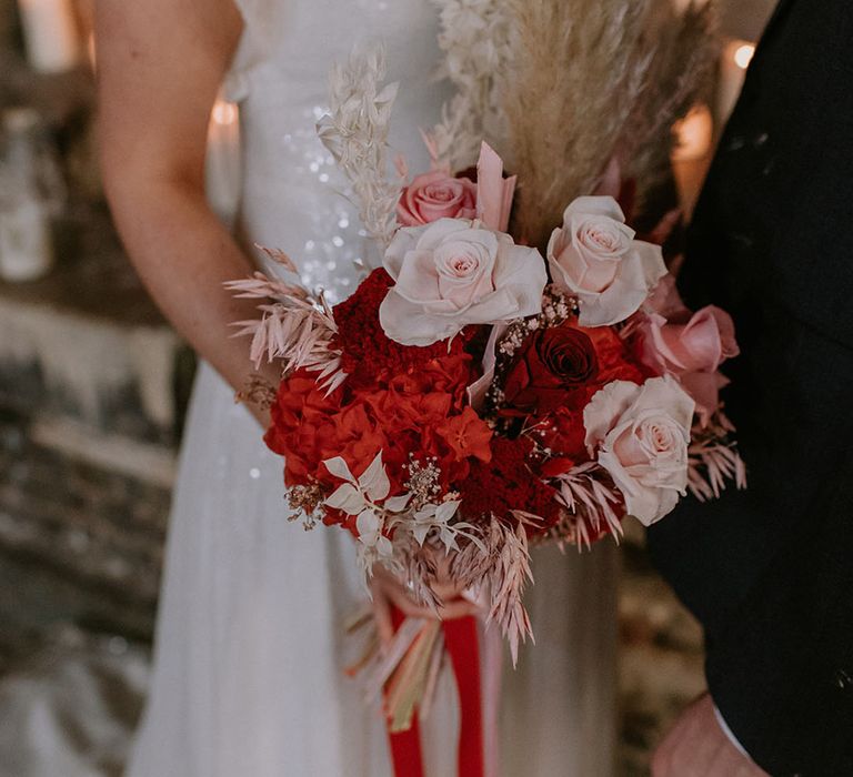 Bride carrying some dried wedding flowers with roses and pampas grass