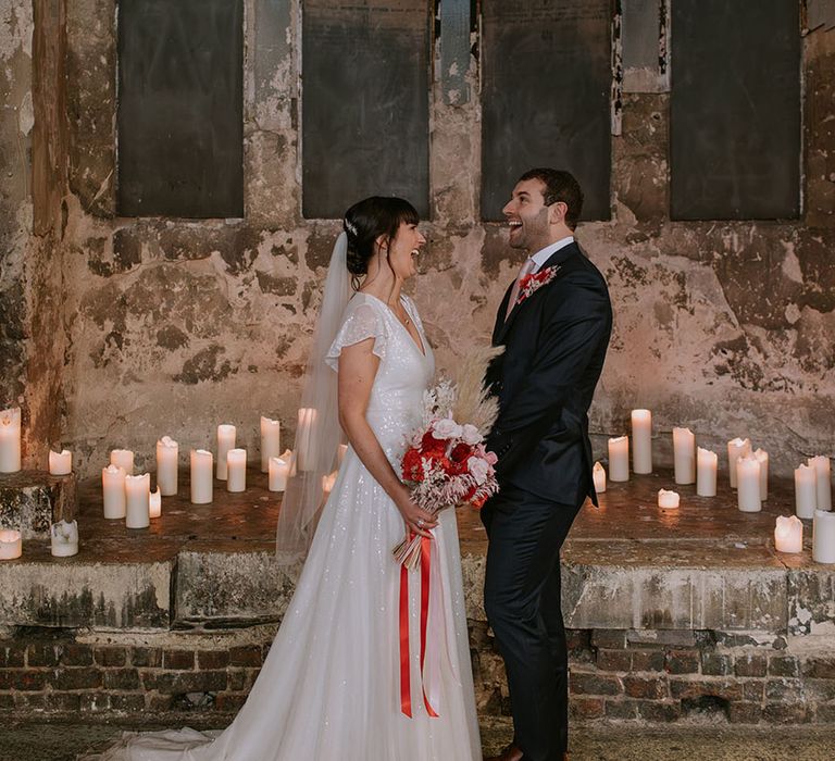 An Asylum Chapel wedding ceremony with the bride wearing a sparkly wedding dress and groom in a navy suit 