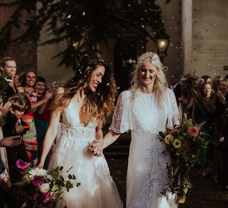 Brides in boho lace wedding dresses walking out of their ceremony to epic confetti moment 