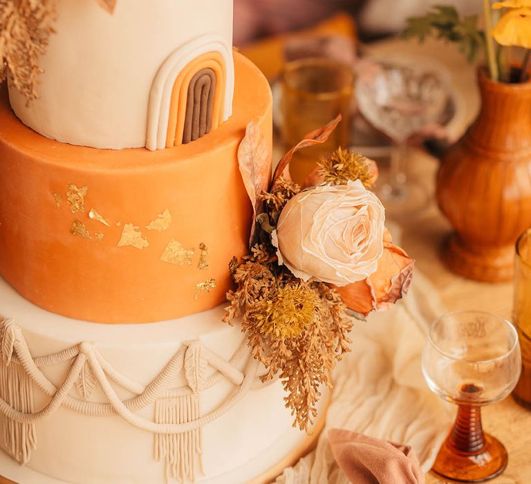 Three tier orange and white iced wedding cake 