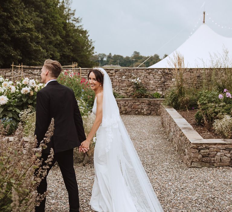 Cute couple portrait of the bride and groom walking around the Casterton Grange Estate wedding venue 