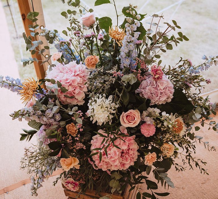 Pastel pink, blue and yellow wedding flower arrangements 