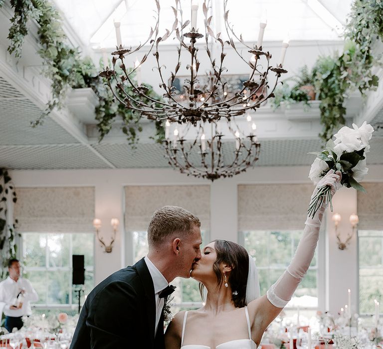 Bride in Aleena Lena wedding dress kissing the groom at their black tie wedding 