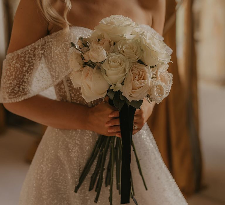 Bride at Christmas wedding holding white rose long stem bouquet 