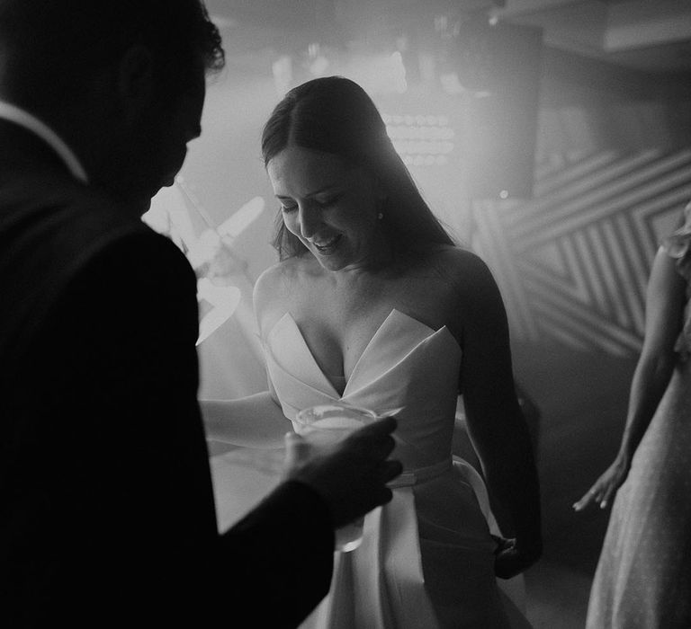 Bride dancing at the wedding reception wearing strapless dress 