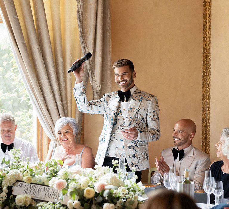 The groom stands with a microphone as he reads out his wedding speech 