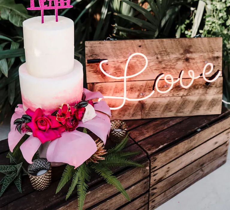 Pink wedding cake with topper reading: "fuck yeah" and "Love" neon light sign by Amy Faith Photography