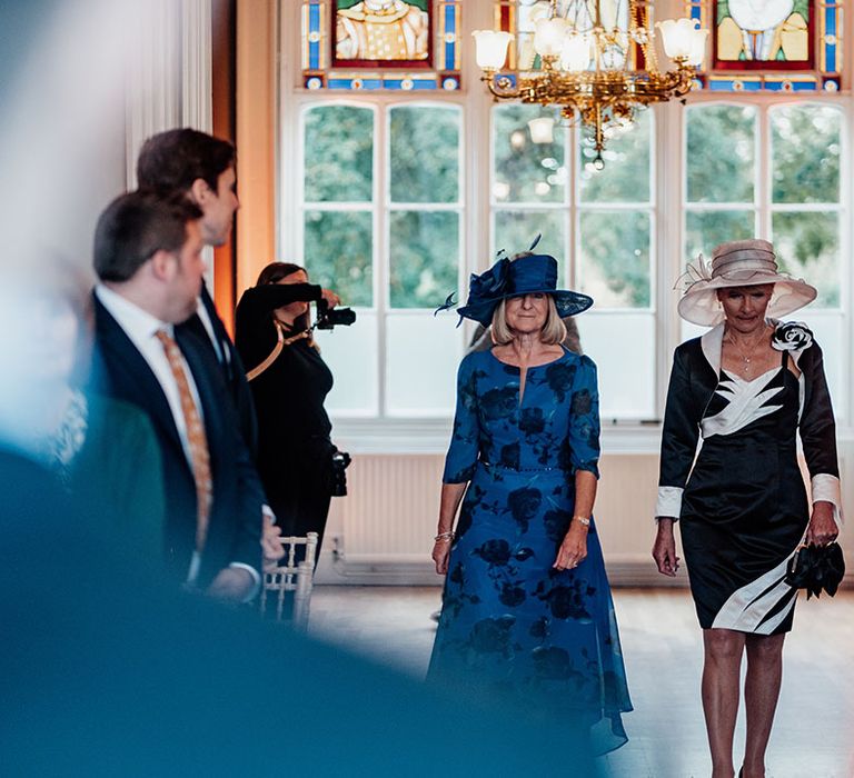 Mothers of the bride and groom walk down the aisle together 