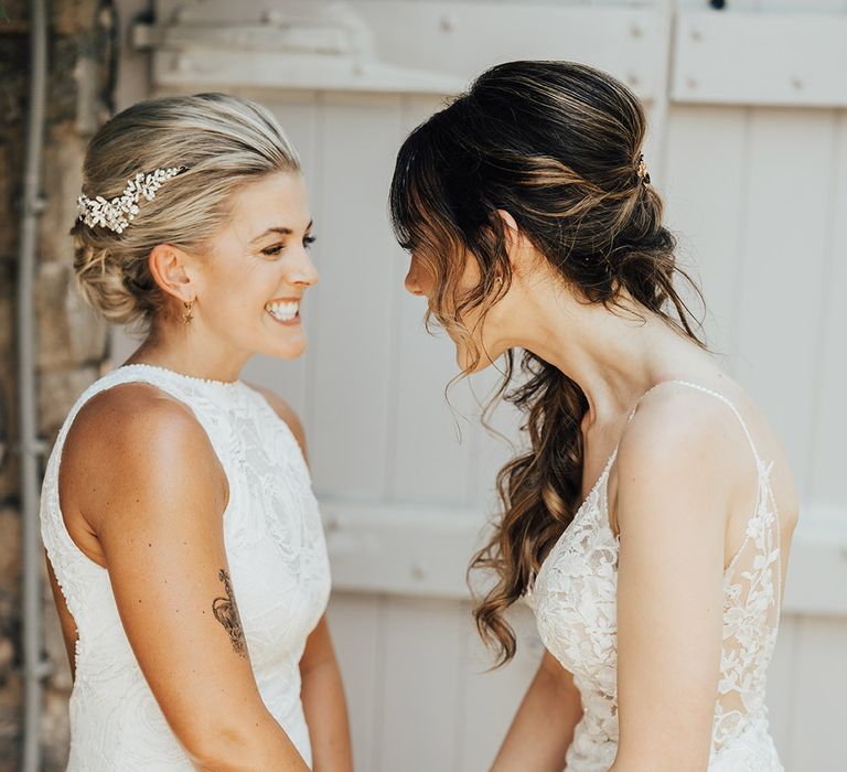 Romantic first look moment between brides as the see each other in their wedding dresses for the first time 