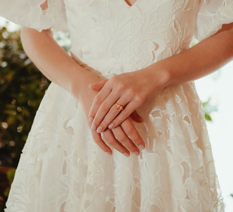 Bride in floral lace wedding dress with short sleeves and plunging neckline 