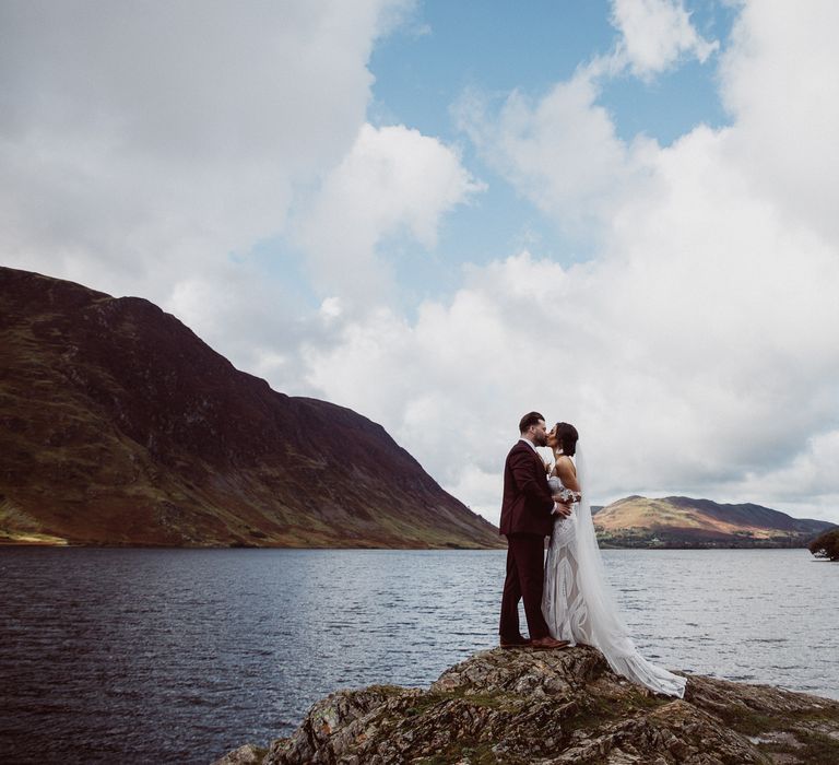 Bride and Groom kissing by a lake at a small wedding in the Lake District