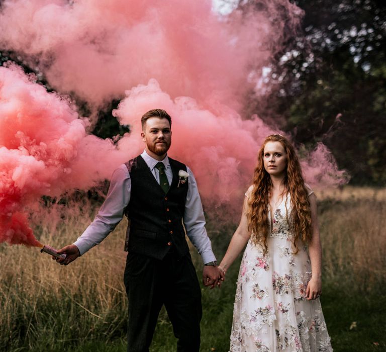 Bride & groom use pink smoke bombs for post-wedding pictures 