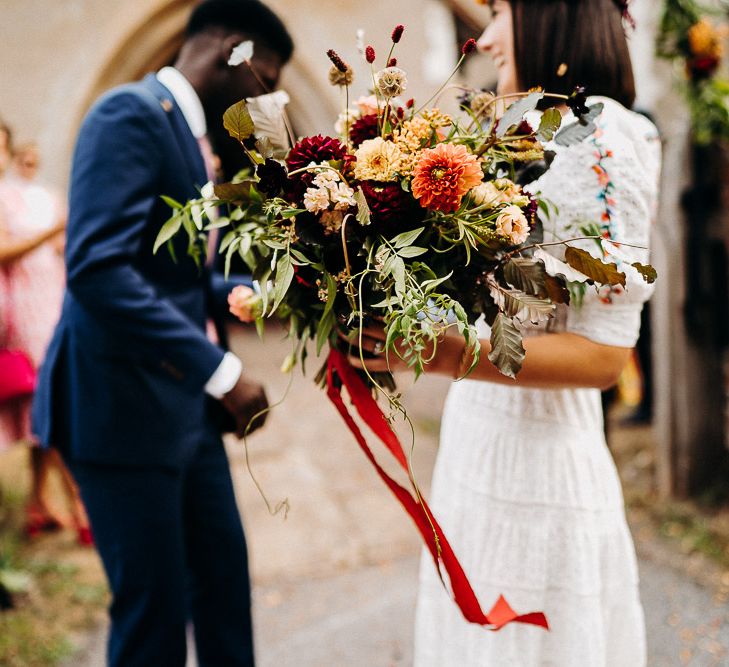 hand tied red and orange dahlia and wildflower wedding bouquet 