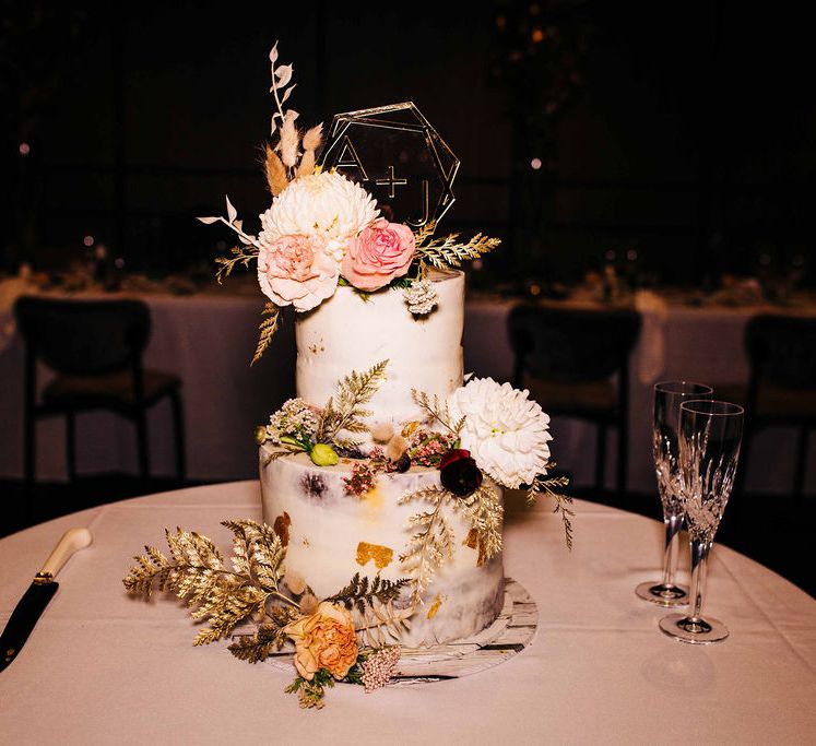 Semi-naked wedding cake with flower decor and personalised cake topper