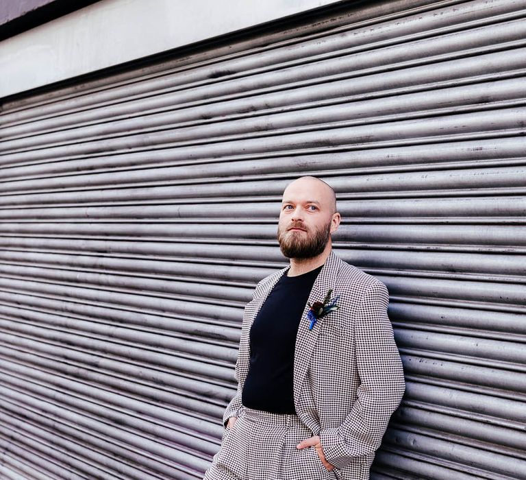 Groom in a check wedding suit, black t-shirt and feather buttonhole 