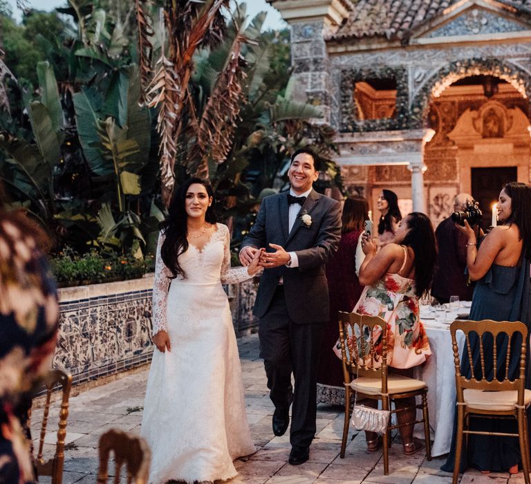 Bride & groom walk into wedding reception in Lisbon as light glows around them