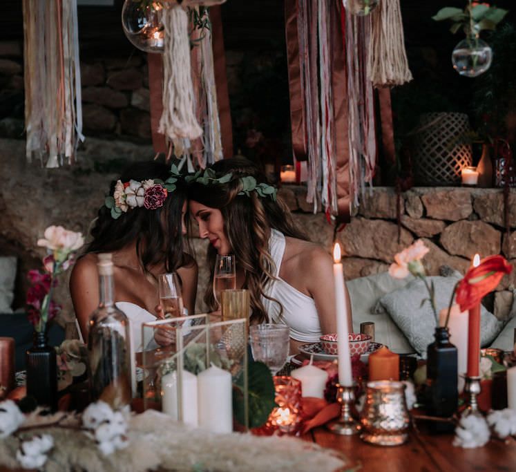 Red, terracotta and macrame candlelit wedding table for two brides in Ibiza