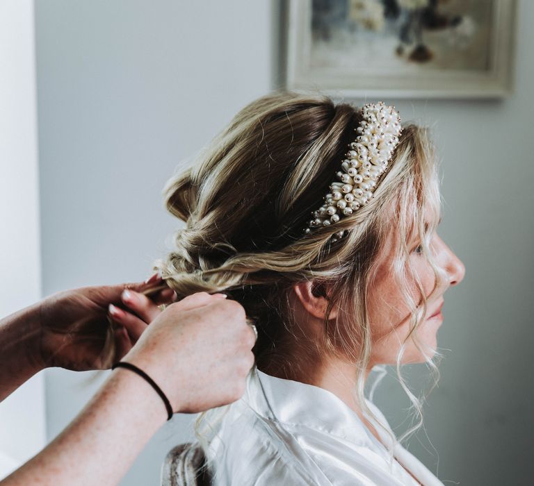 Bride has her blonde hair styled into curls on wedding day with beaded headband