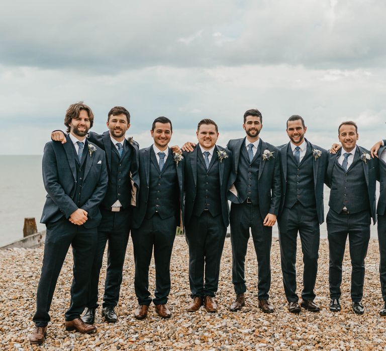 Groom stands with his groomsmen on his wedding day