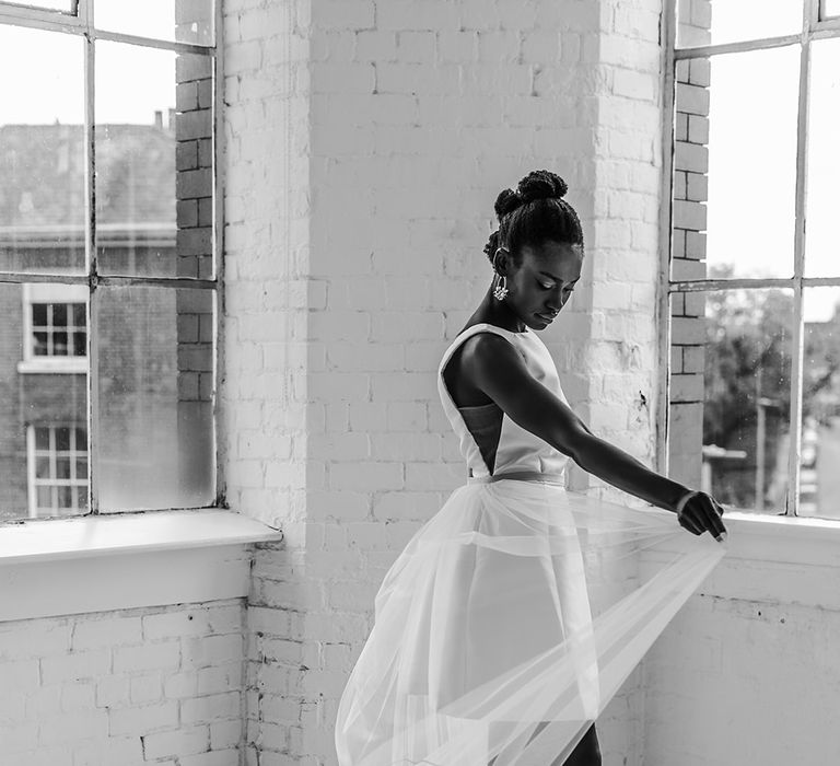 Black bride in a short wedding dress and block heel Charlotte Mills wedding dress swaying her tulle detachable skirt with embroidered flower motif 