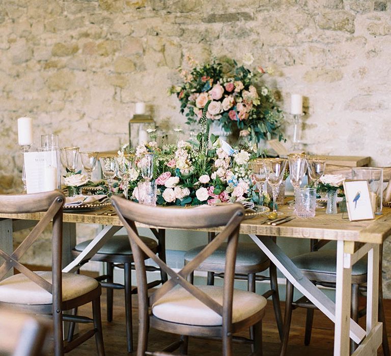 Rustic wedding reception setting complete with wooden tables and pastel florals