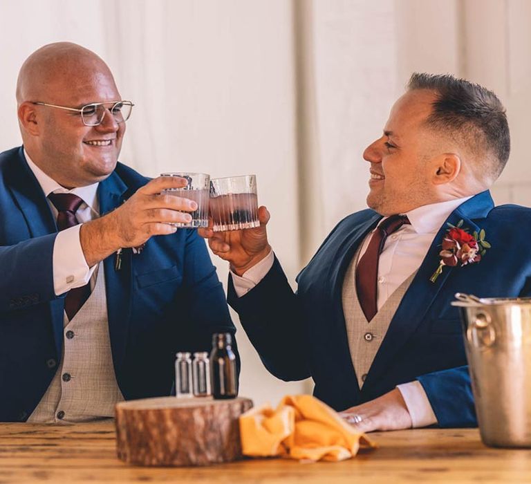 Grooms cheers on their wedding day in blue suits