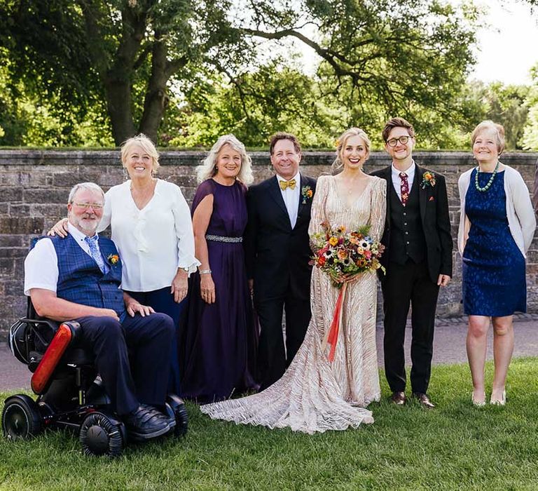 Bride & groom stand with their wedding party on their wedding day outdoors