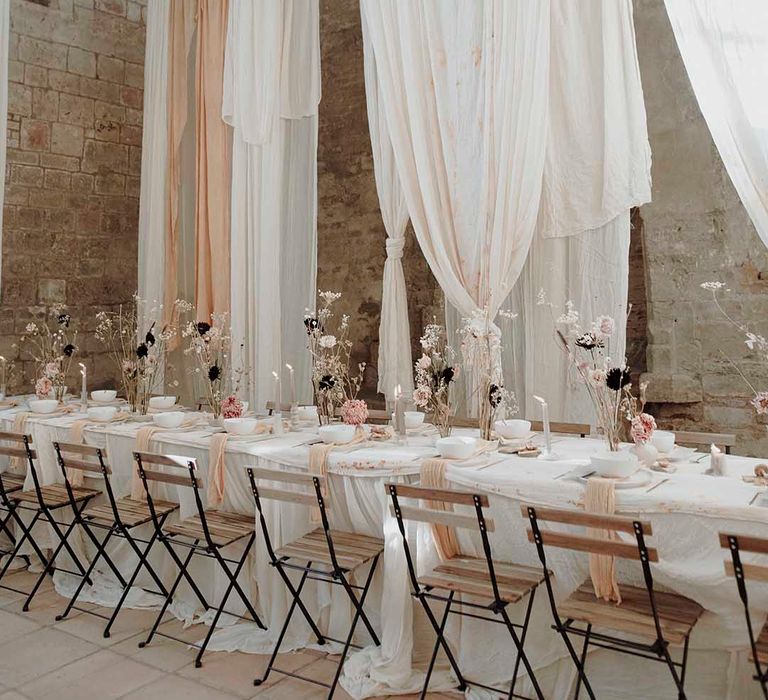 Minimalist wedding reception at Blackfriars Priory with drape installations, dried flowers and candles 