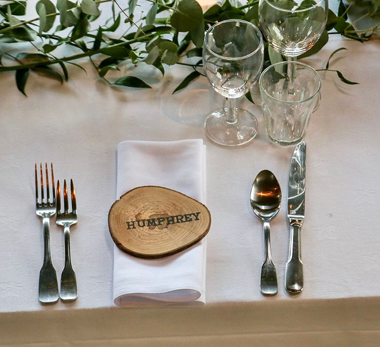 Coasters made of wood complete with name stamped and white napkins with green foliage  table runner 