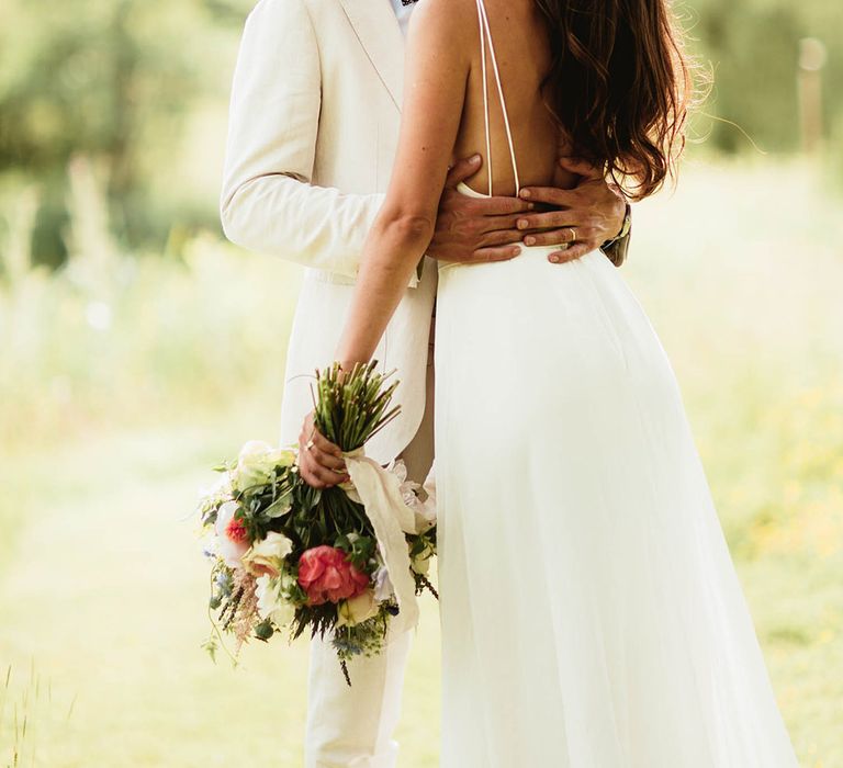 Bride & groom look lovingly at one another outdoors on their wedding day