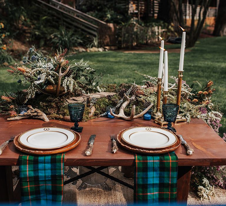 Sweetheart table with blue and green wedding, tartan napkins, antlers, moss and candlesticks table decor 