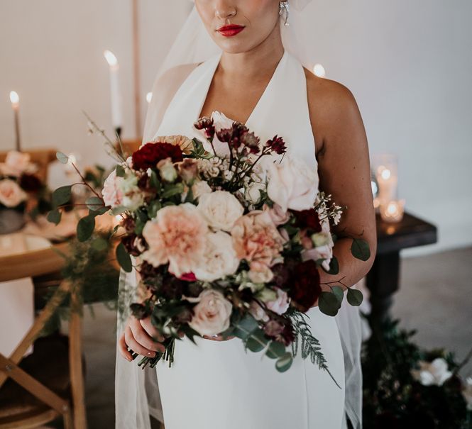 Bride looks across table as she wears deep lipstick