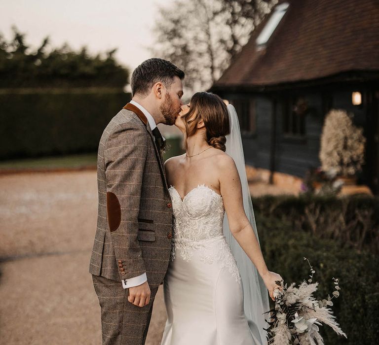 Bride and groom kiss at The Old Kent Barn wedding venue